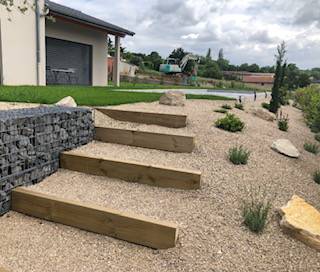 Aménagement d'un jardin avec mur gabion, plantation et marches en bois à l'extérieur à Neuville sur Saône